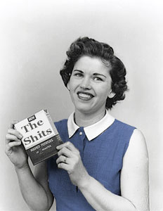 Woman holding a product packet with 'The Shits' written on it