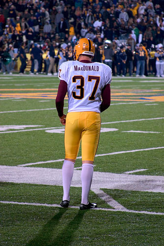 American Football player standing on the sidelines